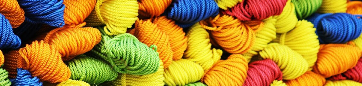 Bundles of yarn in various Hues of Yellow, Orange, Red, Blue and Green