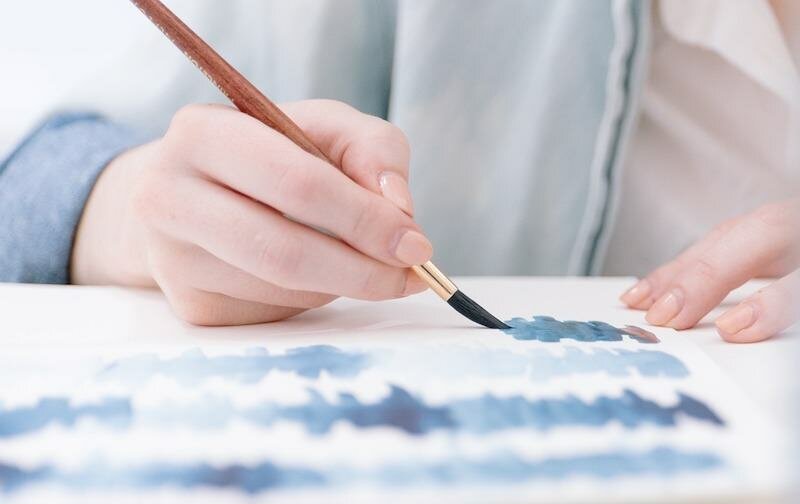 Person painting blue color tests for about page